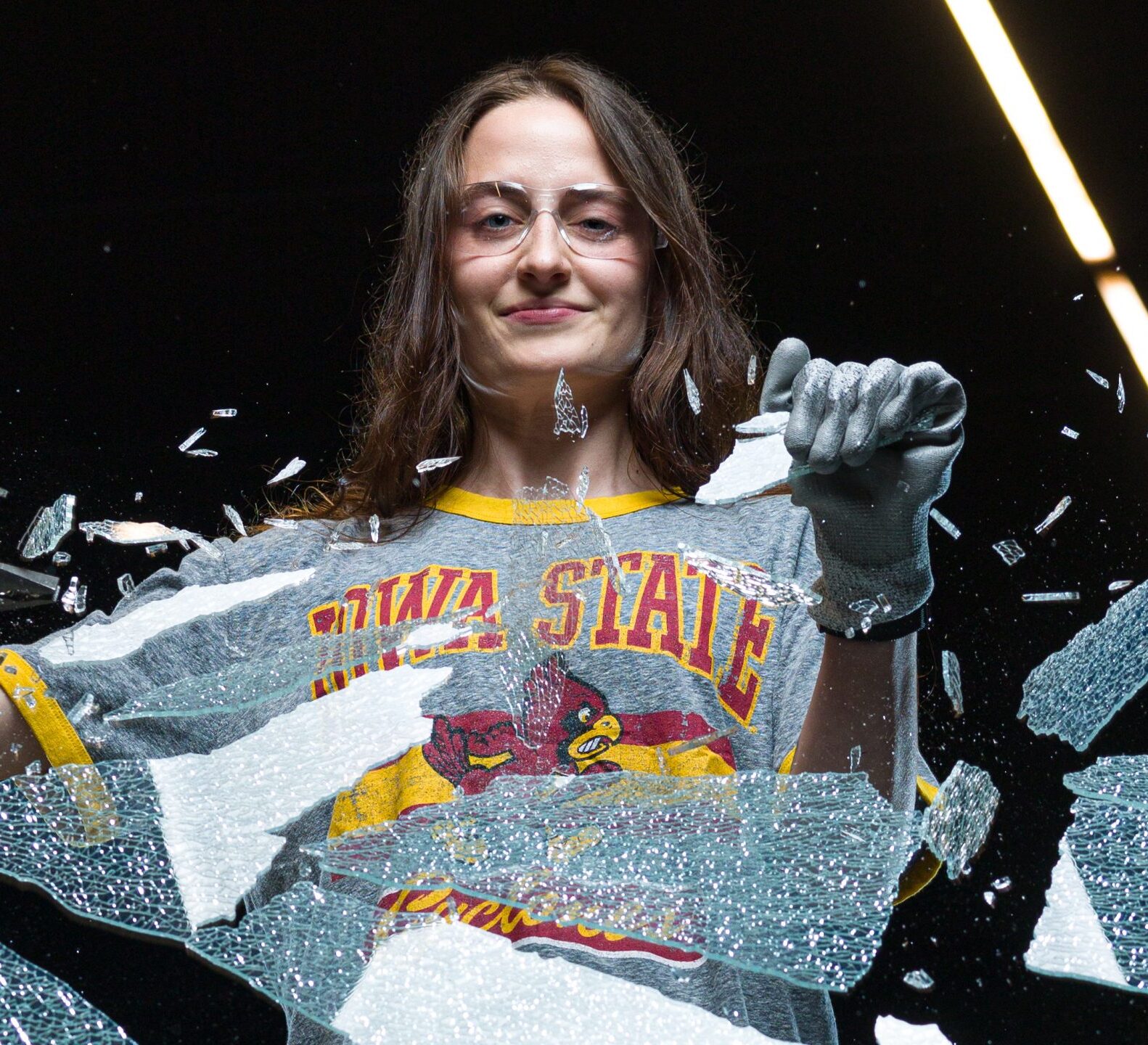 Masha Lebedeva smiles as she breaks a pane of glass in front of her.